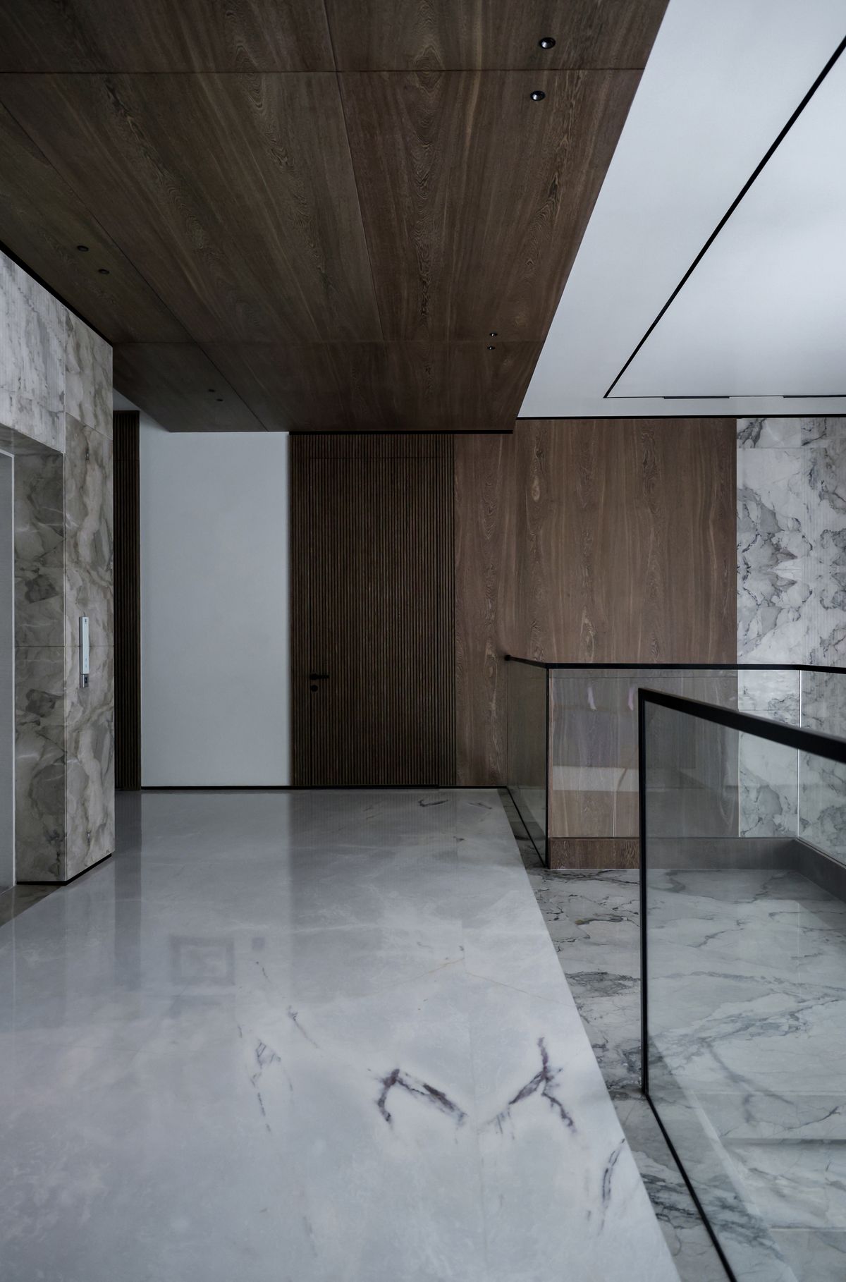 Interior with a timber ceiling, marble walls and floor, and a glass balustrade